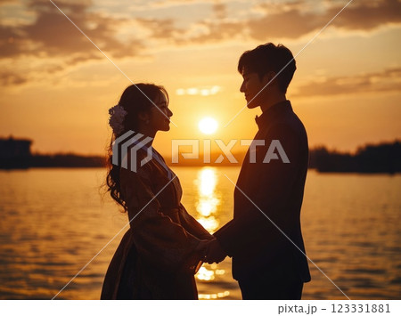 Silhouette of a young couple looking at each other and holding hands with a sunset in the background. Silhouette of a young couple looking at each other and holding hands with a sunset in the background. 123331881