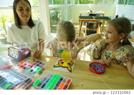 Teacher in workshop teched two girls how to assemble a thermo mosaic  123332063