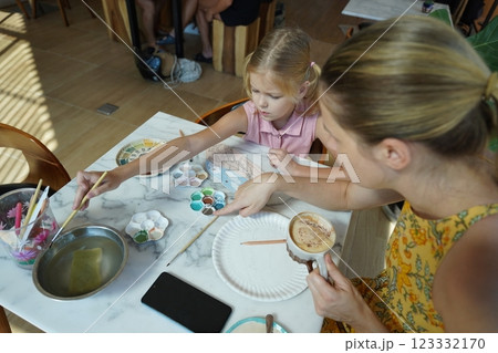 A young mother and her daughter enjoy a creative art session at home A young mother and her daughter enjoy a creative art session at home 123332170