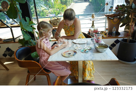 A young mother and her daughter enjoy a creative art session at home A young mother and her daughter enjoy a creative art session at home 123332173