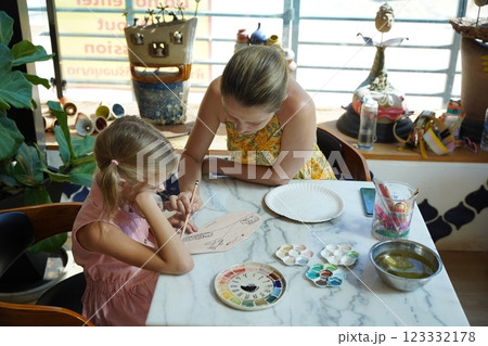 A young mother and her daughter enjoy a creative art session at home  123332178