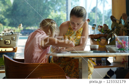 A young mother and her daughter enjoy a creative art session at home  123332179