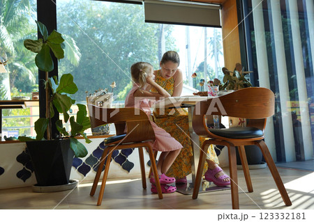 A young mother and her daughter enjoy a creative art session at home A young mother and her daughter enjoy a creative art session at home 123332181