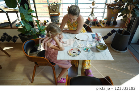 A young mother and her daughter enjoy a creative art session at home  123332182