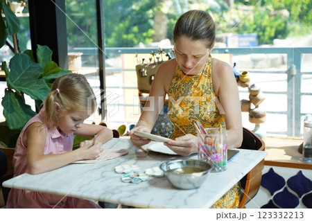 A young mother and her daughter enjoy a creative art session at home  123332213