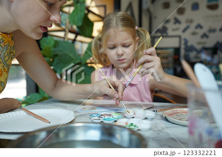 A young mother and her daughter enjoy a creative art session at home A young mother and her daughter enjoy a creative art session at home 123332221