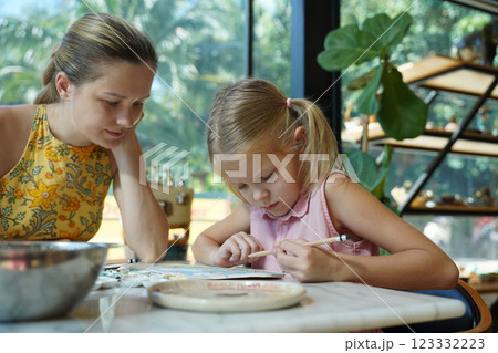 A young mother and her daughter enjoy a creative art session at home A young mother and her daughter enjoy a creative art session at home 123332223