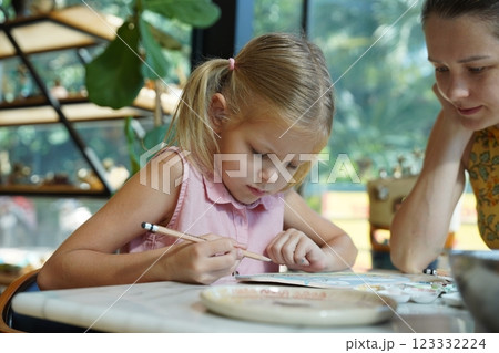 A young mother and her daughter enjoy a creative art session at home A young mother and her daughter enjoy a creative art session at home 123332224
