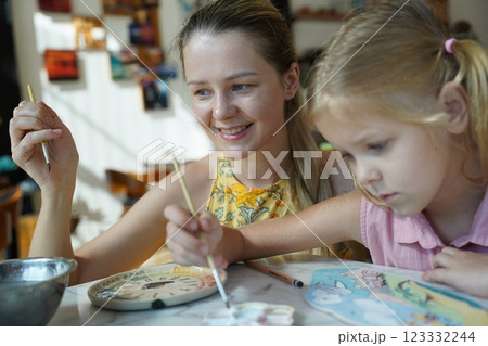 A young mother and her daughter enjoy a creative art session at home  123332244