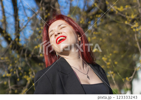 Woman with flowers surrounded by blossoming trees . Beauty and seasonal change and spring bloom season concept. 123333243