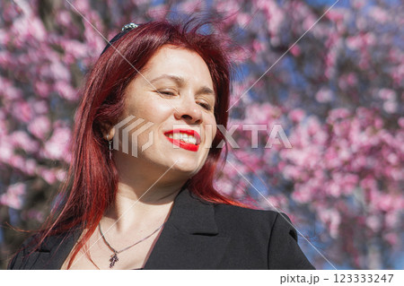 Woman with cherry flowers surrounded by blossoming trees copy space. Beauty and seasonal change and spring bloom season concept. Woman with cherry flowers surrounded by blossoming trees copy space. Beauty and seasonal change and spring bloom season concept. 123333247