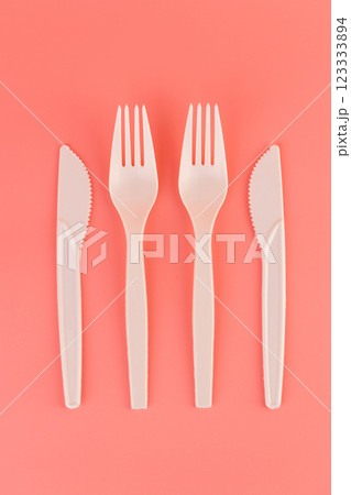 top shot close-up on soft pink background pair of plastic white knives and forks disposable tableware eco technology reusable care for planet picnic set top shot close-up on soft pink background pair of plastic white knives and forks disposable tableware eco technology reusable care for planet picnic set 123333894