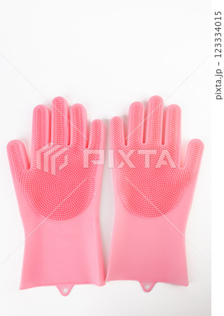 close up On white background lie large thick rubber pink gloves with texture for easy dish washing replacement sponge for dishes care of hands protection from chemicals close up On white background lie large thick rubber pink gloves with texture for easy dish washing replacement sponge for dishes care of hands protection from chemicals 123334015