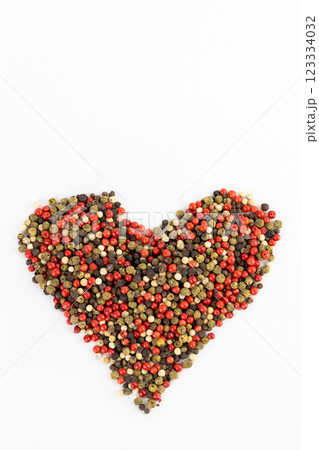 closeup white background a pile of mixed large aromatic peppers black red and white the main seasoning for food peppercorns indian and european spices pepper laid out in the shape of a heart closeup white background a pile of mixed large aromatic peppers black red and white the main seasoning for food peppercorns indian and european spices pepper laid out in the shape of a heart 123334032