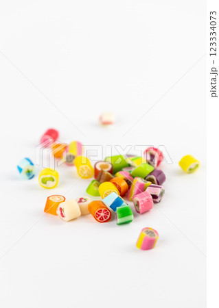 on white background in a small multi-colored sugar caramels with different flavors and patterns lie children's favorite sweets a large selection risk of caries blood sugar excess weight 123334073