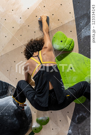 fit woman exercising on climbing wall in gym fit woman exercising on climbing wall in gym 123334143