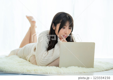 うつ伏せでパソコンを触る女性 うつ伏せでパソコンを触る女性 123334150