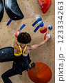 fit woman exercising on climbing wall in gym 123334263