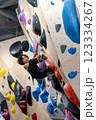 fit woman exercising on climbing wall in gym 123334267