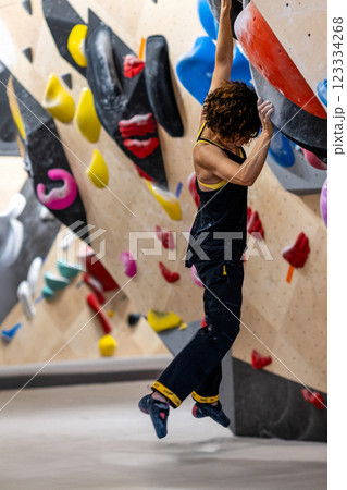 fit woman exercising on climbing wall in gym 123334268