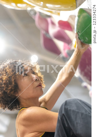 fit woman exercising on climbing wall in gym 123334274