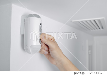 man connects the camera of a burglar alarm man connects the camera of a burglar alarm 123334378