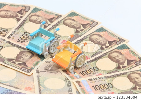 車椅子と紙幣のイメージ 123334604