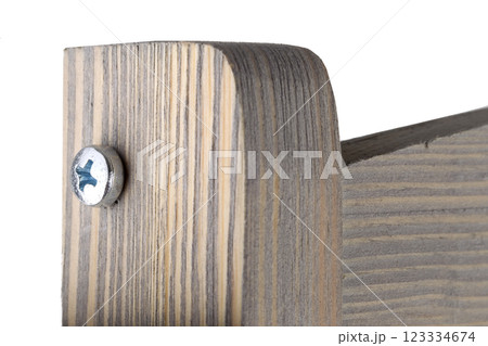 Fragment of a wooden product with a screw on a white background close-up 123334674