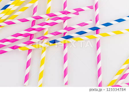 top shot on white background there are many paper striped colored tubes for cocktails and different drinks pink yellow and blue striped tubes spring mood 123334784