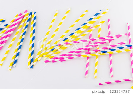 top shot on white background there are many paper striped colored tubes for cocktails and different drinks pink yellow and blue striped tubes spring mood 123334787