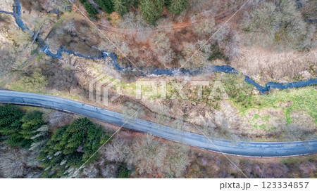 Aerial view of a winding road through a lush forest, showcasing outdoor beauty and adventure 123334857