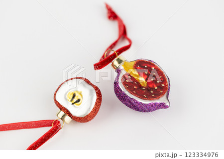 Christmas tree toys in the shape of apple fruit lie on white background and figs on a red rope glass New Year toys modern decor 123334976