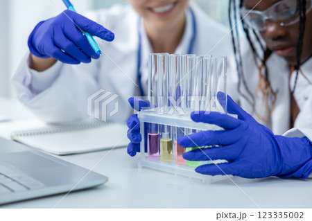Diverse scientist working with test tube in laboratory conducting experiment for cure research Diverse scientist working with test tube in laboratory conducting experiment for cure research 123335002