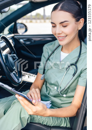 Female doctor sitting in a care and scrutinizing a prescription list Female doctor sitting in a care and scrutinizing a prescription list 123335179