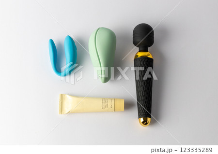 top shot close-up close-up white background lie a black large vibrator in the shape of a microphone next to it lie a vacuum mint and with double penetration blue vibrators a tube of lubricant various 123335289