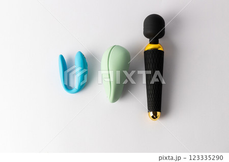 top shot close-up on a white background lie a black large vibrator in the shape of a microphone next to it lie a vacuum mint and with double penetration blue vibrators various sex toys 123335290