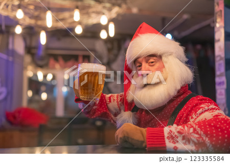 Santa Claus drinking beer at a bar.  123335584