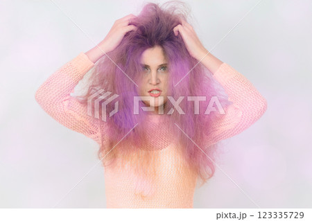 A woman with purple hair is wearing a pink shirt. 123335729