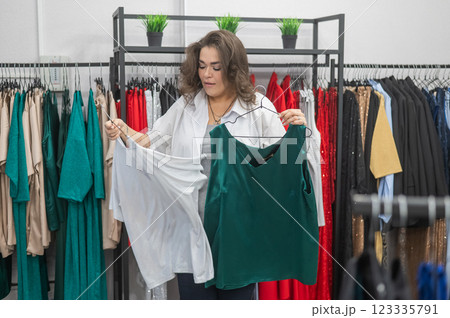 Caucasian fat woman chooses clothes. Plus size store. Caucasian fat woman chooses clothes. Plus size store. 123335791