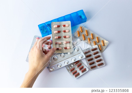 on white background on an outstretched female hand a silver blister with colored capsules suicidal thoughts depression health care pills in the air medical care others on the table pill box 123335808
