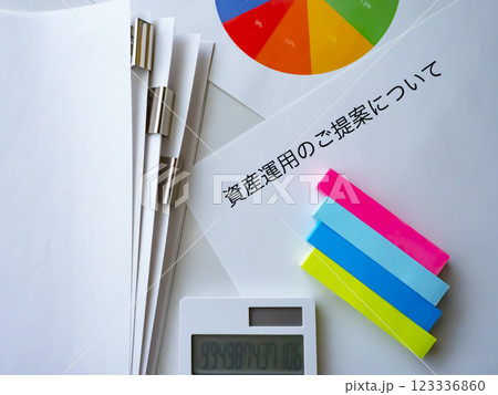 テーブルに置かれたグラフと書類と電卓 123336860