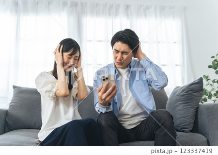 スマホを見ながら怯えるカップル 123337419