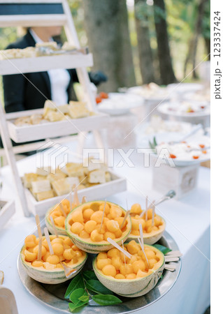 Cantaloupe carving baskets with spoons stand on a served table 123337424