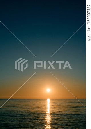 Sparkling path from the rays of the orange sunset sun on the sea 123337527