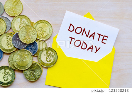 Donate Today text on white paper covered with yellow envelope. 123338218