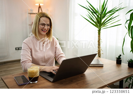 Working happily from home in a cozy environment surrounded by greenery and warm light 123338651