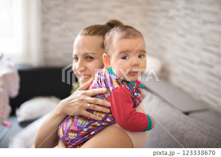Caring mother holding newborn baby girl at home 123338670