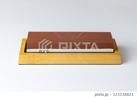 closeup white background on table lies red equipment a set for sharpening and polishing kitchen knives and various blades different abrasiveness of stones a retainer for knives 123338823