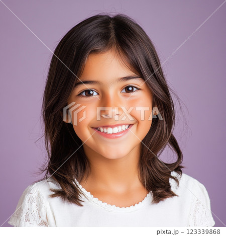 A vibrant portrait of a cheerful Hispanic girl with natural brown hair, exuding a warm, confident smile, ideal for capturing positive energy in product advertising 123339868