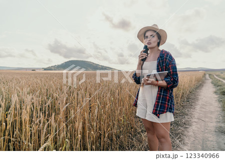Woman in a Wheat Field with a Microphone and Tablet 123340966